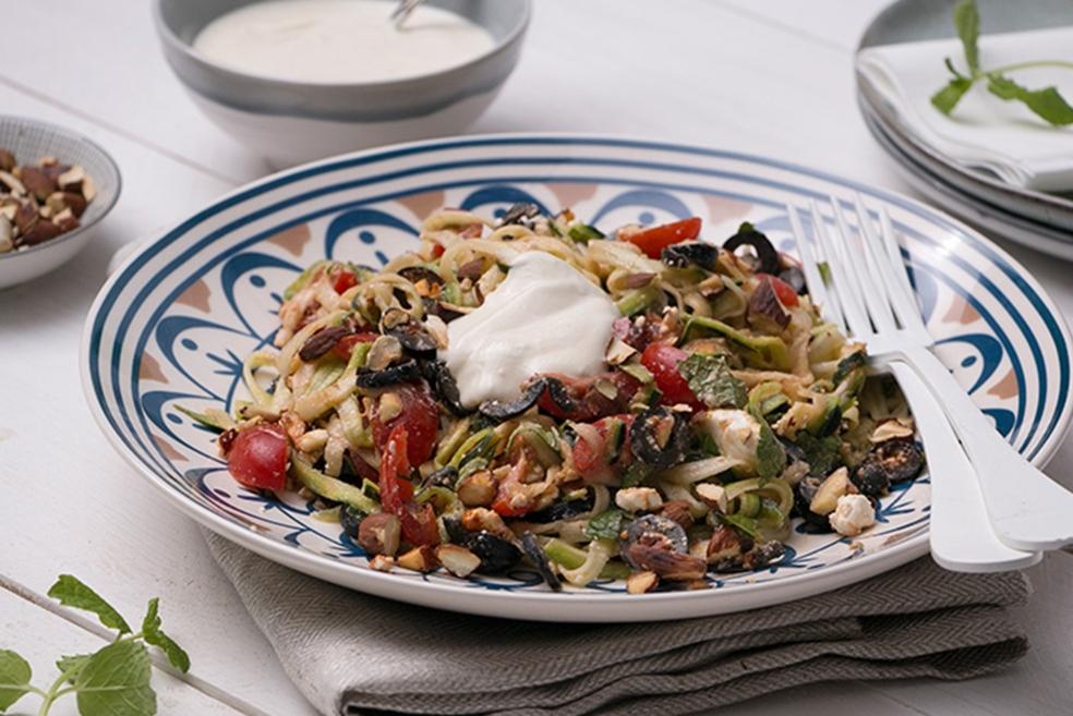 Courgetti met hummus-/yoghurtdressing, olijven, feta en kerstomaatjes