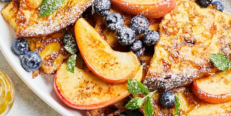 Wentelteefjes van panettone met gebakken appeltjes, blauwe bessen en munt