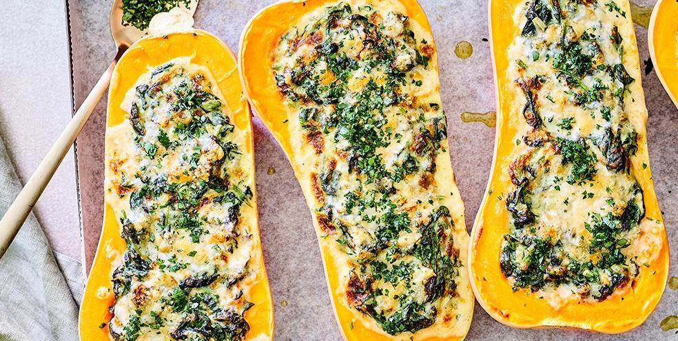 Geroosterde pompoen gevuld met romige spinazie