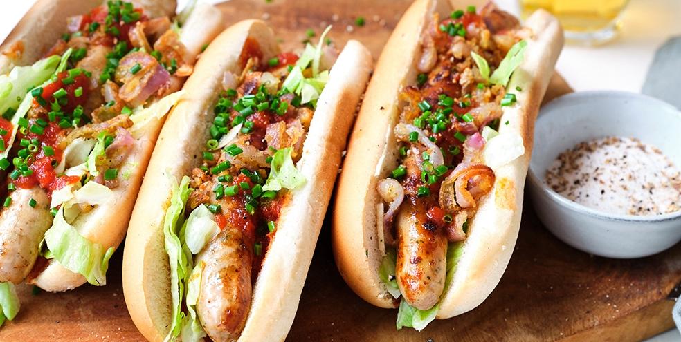 Broodje chipolata met paprikaketchup en krokante uitjes